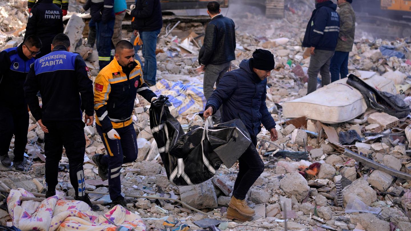Adana in der Türkei: Zwei Männer tragen eine Leiche aus einem zerstörten Gebäude.