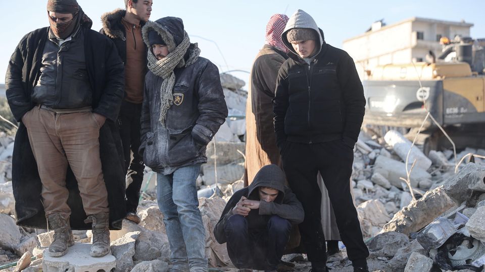 Bewohner in der nordsyrischen Stadt Harim inspizieren ein eingestürztes Gebäude