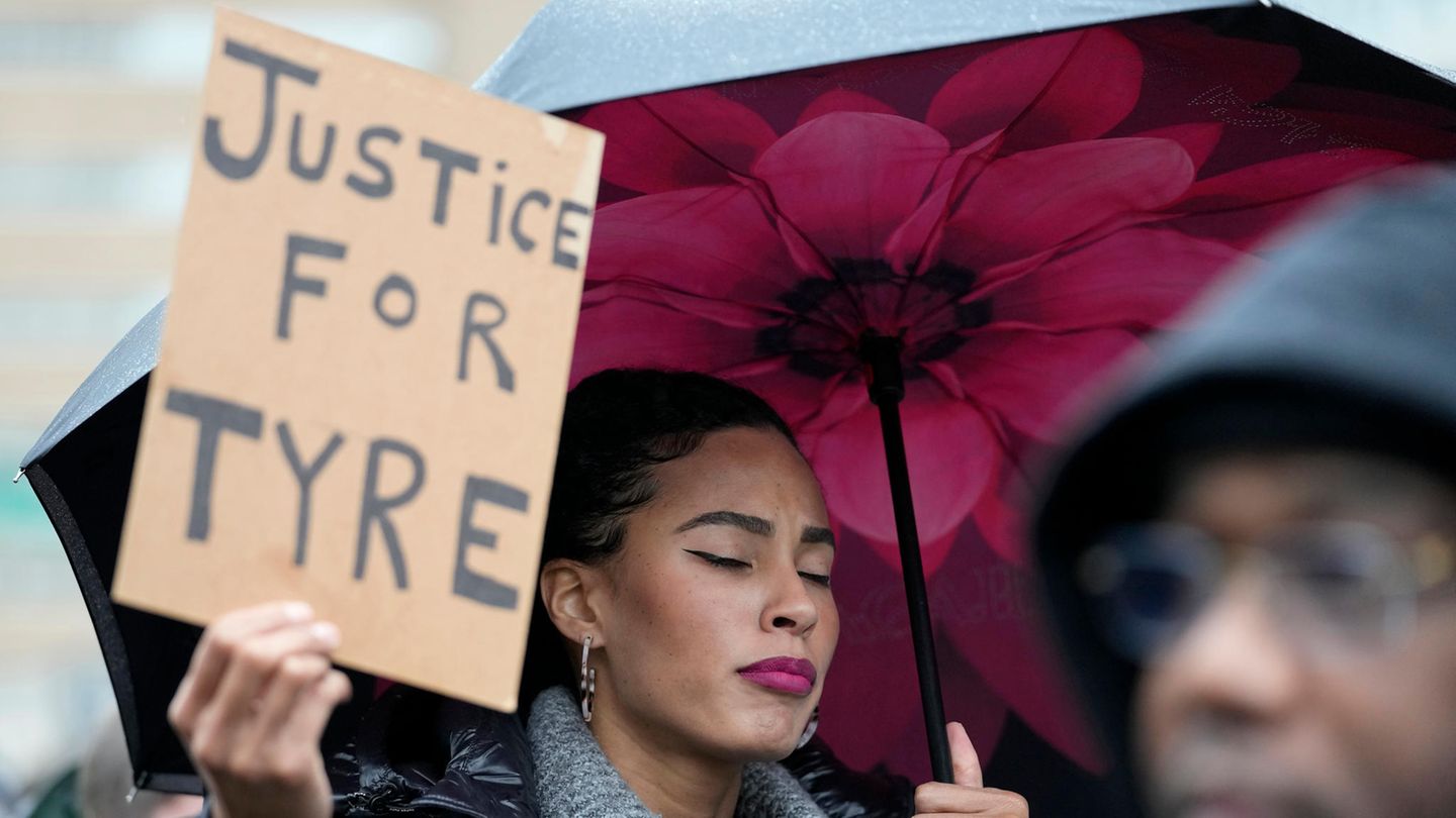 Eine Frau hält ein Schild mit der Aufschrift "Justice for Tyre"