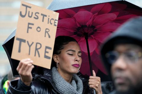 Eine Frau hält ein Schild mit der Aufschrift "Justice for Tyre"