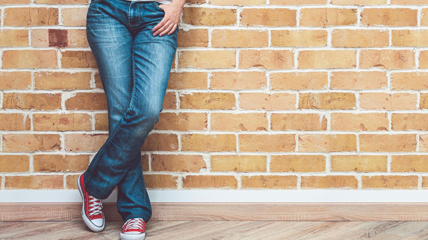 Eine Frau trägt Jeans und Sneaker