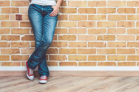 Eine Frau trägt Jeans und Sneaker