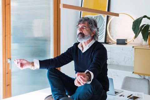 Ein Mann sitzt in Yoga-Pose