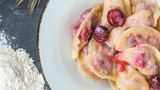 Mit Sauerkirschen gefüllte Wareniki  Zutaten:  Für den Teig:  · 450 g Weizenmehl ·1Ei ·  1/2 TL Salz ·  1/2 TL Zucker ·  250 ml Kefir oder dünnflüssigen Naturjoghurt ·  1/2 TL Backpulver ·  100 g Sauerrahm  Für die Füllung:  · 400 g Sauerkirschen ·1 EL Grieß ·2 –3 EL Zucker · 50 g Butter, zerlassen  45 Minuten, 4 Personen  Zubereitung:  1. Für den Teig das Mehl mit den Eiern, Salz, Zucker, Kefir (oder Naturjoghurt) und Backpulver vermischen. Der Teig sollte weich und elastisch, aber nicht klebrig sein. Den Teig zu einer Kugel formen, in eine mit Öl ausgepinselte Schüssel legen und mit einem Geschirrtuch bedeckt 15–20 Minuten ruhen lassen.  2. Parallel die Füllung vorbereiten und dafür die Kirschen entkernen (außerhalb der Saison TK- Sauerkirschen auftauen). Die Kirschen mit dem Zucker und dem Grieß vermischen.  3. Jeweils eine kleine Teigportion ausrollen, 1 EL Kirschen in die Mitte geben und den Teig da- rum zusammenschlagen. Wer statt Knödeln halbmondförmige Teigtaschen formt, kann die Ränder dekorativ mit den Zinken einer Gabel eindrücken.  4. Die Wareniki im kochenden Salzwasser ziehen lassen, bis sie an die Oberfläche steigen. Die fertigen Knödel mit Zucker bestreuen, damit sie nicht aneinander kleben, und mit zerlasse- ner Butter beträufeln.  5. Mit Sauerrahm oder Kirschsauce (kysil) servieren.
