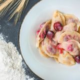 Mit Sauerkirschen gefüllte Wareniki  Zutaten:  Für den Teig:  · 450 g Weizenmehl ·1Ei ·  1/2 TL Salz ·  1/2 TL Zucker ·  250 ml Kefir oder dünnflüssigen Naturjoghurt ·  1/2 TL Backpulver ·  100 g Sauerrahm  Für die Füllung:  · 400 g Sauerkirschen ·1 EL Grieß ·2 –3 EL Zucker · 50 g Butter, zerlassen  45 Minuten, 4 Personen  Zubereitung:  1. Für den Teig das Mehl mit den Eiern, Salz, Zucker, Kefir (oder Naturjoghurt) und Backpulver vermischen. Der Teig sollte weich und elastisch, aber nicht klebrig sein. Den Teig zu einer Kugel formen, in eine mit Öl ausgepinselte Schüssel legen und mit einem Geschirrtuch bedeckt 15–20 Minuten ruhen lassen.  2. Parallel die Füllung vorbereiten und dafür die Kirschen entkernen (außerhalb der Saison TK- Sauerkirschen auftauen). Die Kirschen mit dem Zucker und dem Grieß vermischen.  3. Jeweils eine kleine Teigportion ausrollen, 1 EL Kirschen in die Mitte geben und den Teig da- rum zusammenschlagen. Wer statt Knödeln halbmondförmige Teigtaschen formt, kann die Ränder dekorativ mit den Zinken einer Gabel eindrücken.  4. Die Wareniki im kochenden Salzwasser ziehen lassen, bis sie an die Oberfläche steigen. Die fertigen Knödel mit Zucker bestreuen, damit sie nicht aneinander kleben, und mit zerlasse- ner Butter beträufeln.  5. Mit Sauerrahm oder Kirschsauce (kysil) servieren.