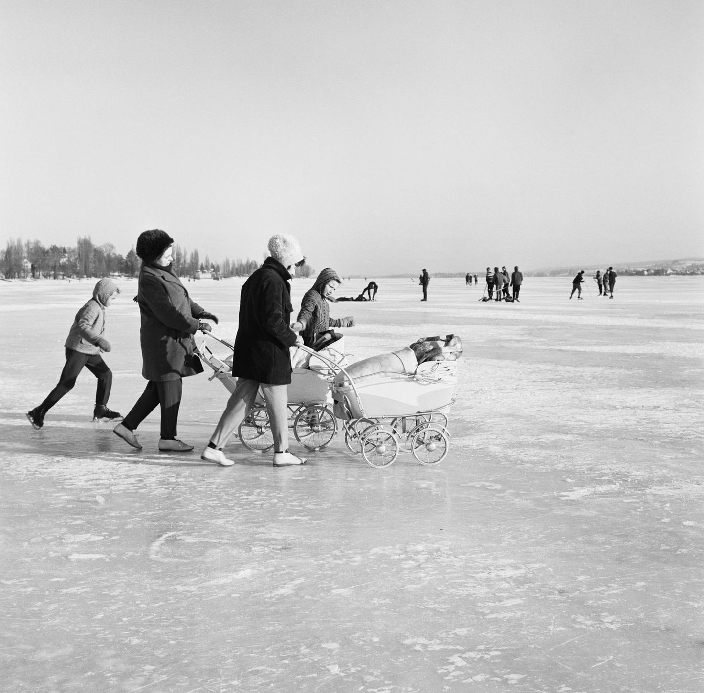 Mütter mit ihren Kindern und Kinderwagen auf dem zugefrorenen Untersee bei Reichenau