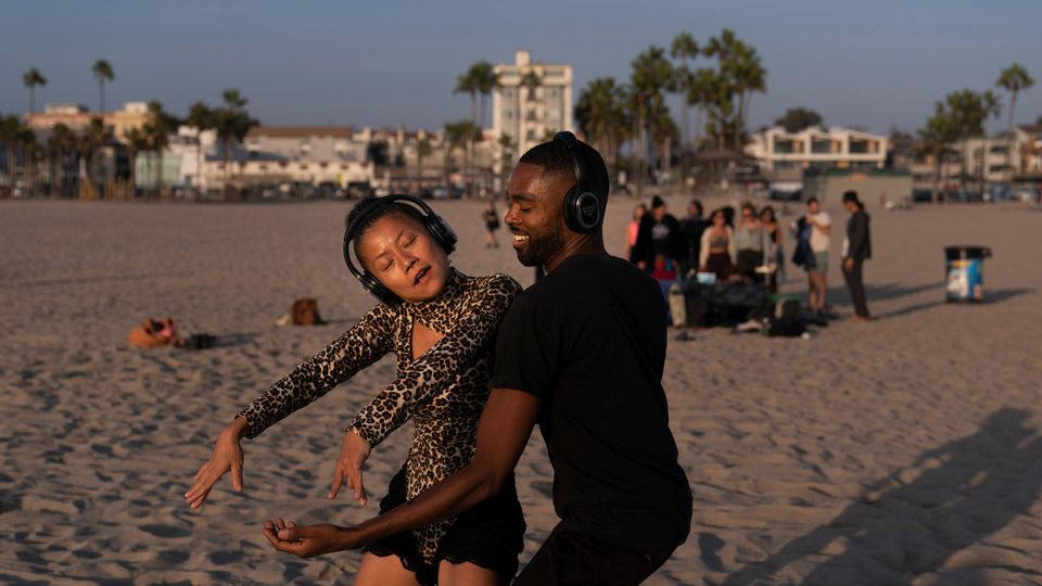 Mann und Frau tanzen gemeinsam am Strand