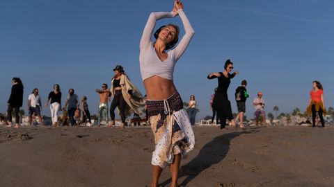 Frau tanzt am Strand