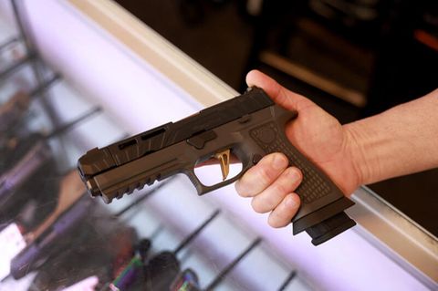 Ein Mann hält eine Sig Sauer P320 Handfeuerwaffe. In Missouri ist das öffentliche Tragen von Waffen erlaubt