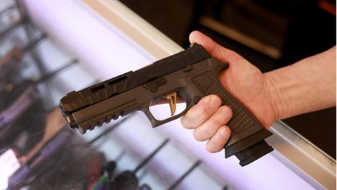 Ein Mann hält eine Sig Sauer P320 Handfeuerwaffe. In Missouri ist das öffentliche Tragen von Waffen erlaubt
