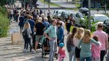 Zahlreiche Menschen stehen in einer langen Schlange vor den Wahllokalen