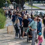 Zahlreiche Menschen stehen in einer langen Schlange vor den Wahllokalen