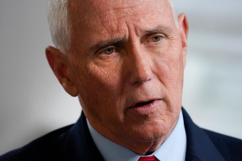 Mike Pence, ein weißer Mann mit weißem Haar, legt beim Sprechen den Kopf schräg. Er trägt eine rote Krawatte zum blauen Anzug