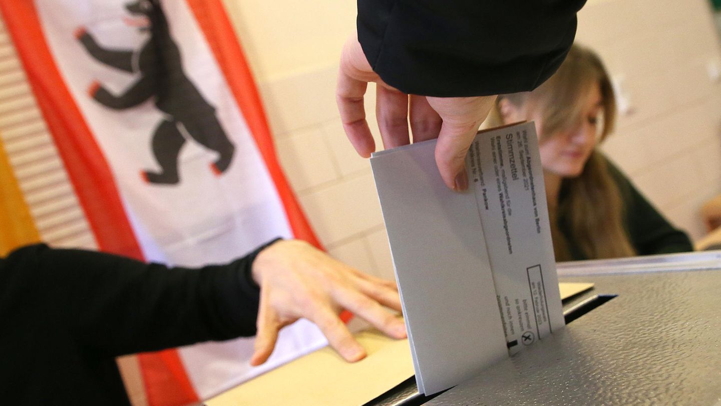 Wiederholungswahl in Berlin: Eine Frau wirft ihren Stimmzettel in eine Wahlurne