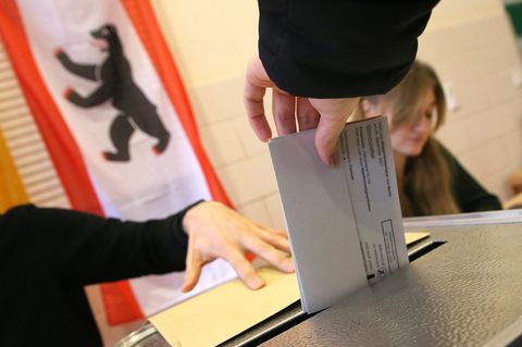 Wiederholungswahl in Berlin: Eine Frau wirft ihren Stimmzettel in eine Wahlurne