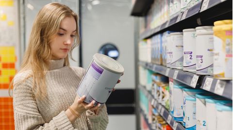 Eine Frau schaut sich Milchpulver-Produkte an