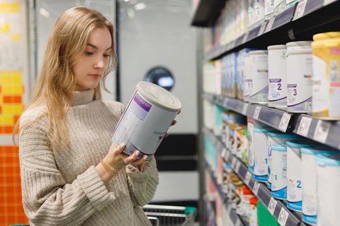 Eine Frau schaut sich Milchpulver-Produkte an