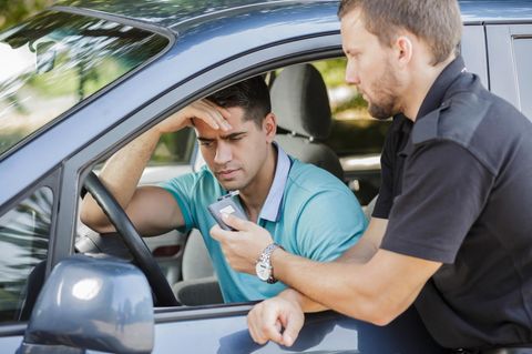 Polizist misst Alkoholpegel bei Autofahrer