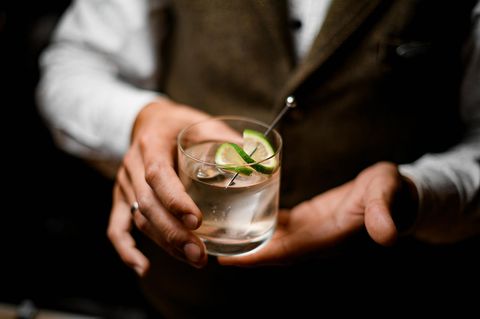 Barkeeper hält einen Gin Tonic in der Hand