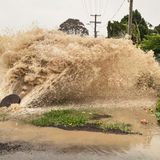 Neuseeland: Wasser sprudelt aus einer Regenwasseröffnung in einer Straße in Te Awanga