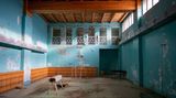 Turnhalle mit fleckiger türkiser Wandfarbe