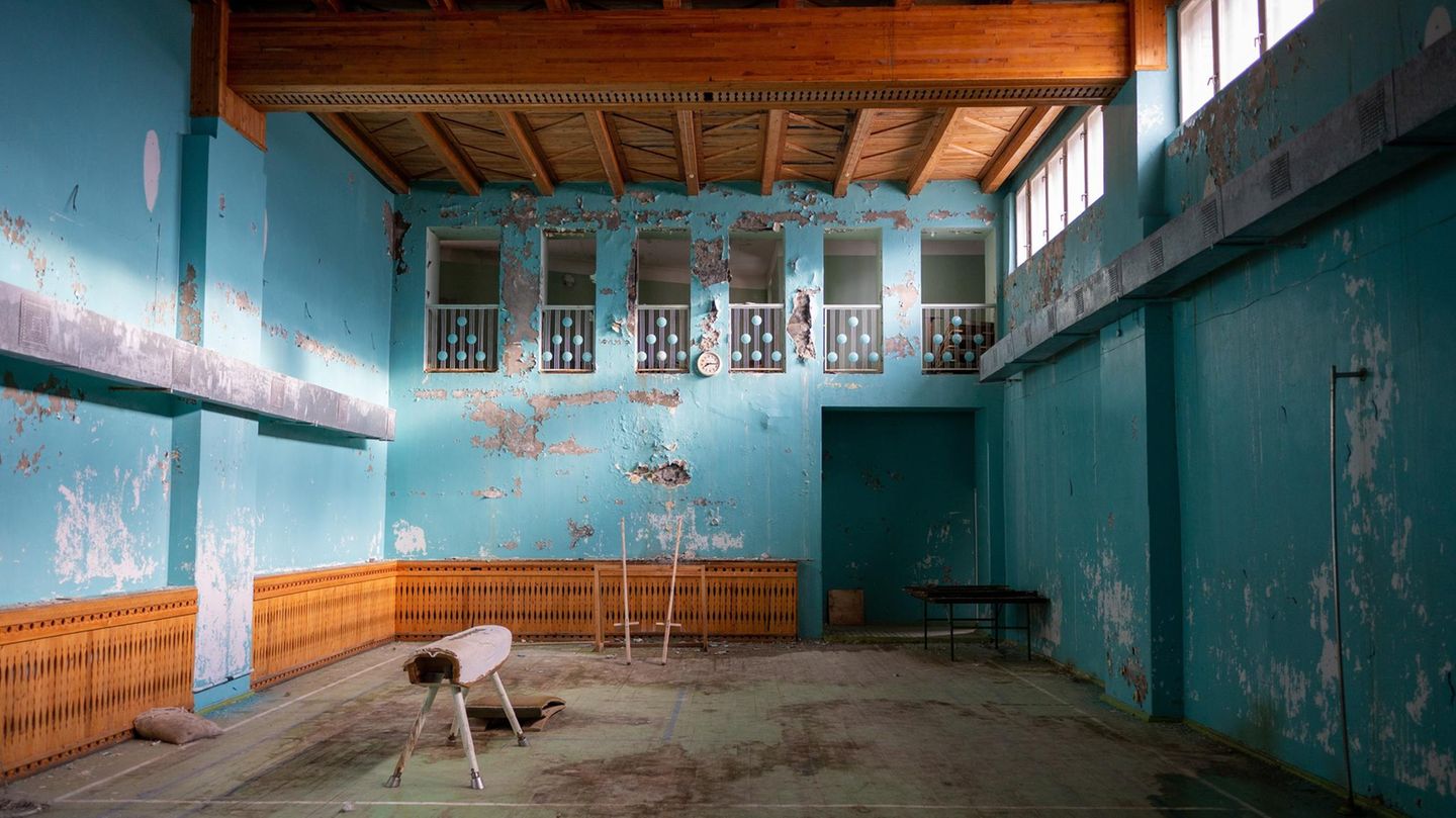 Turnhalle mit fleckiger türkiser Wandfarbe