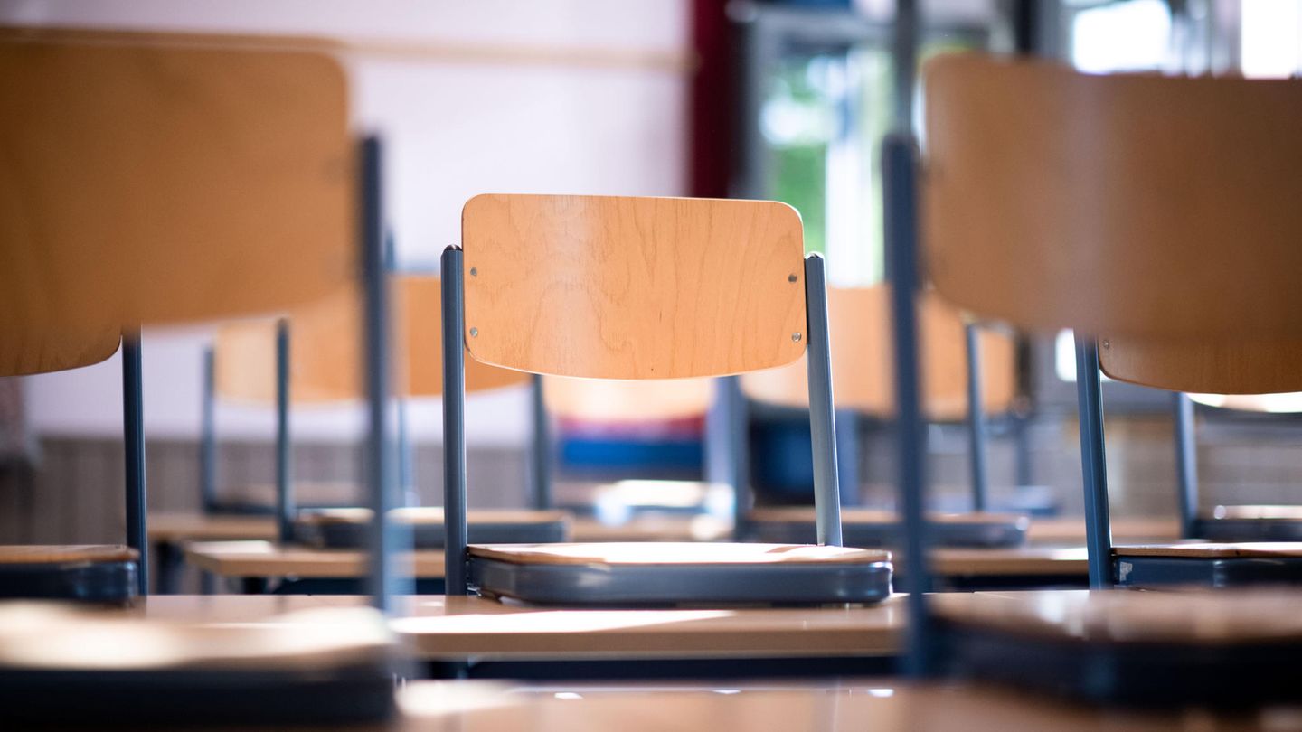 Stühle stehen in einem leeren Klassenraum in einer Schule auf den Tischen