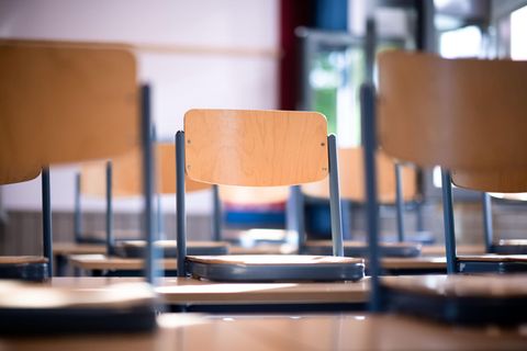 Stühle stehen in einem leeren Klassenraum in einer Schule auf den Tischen