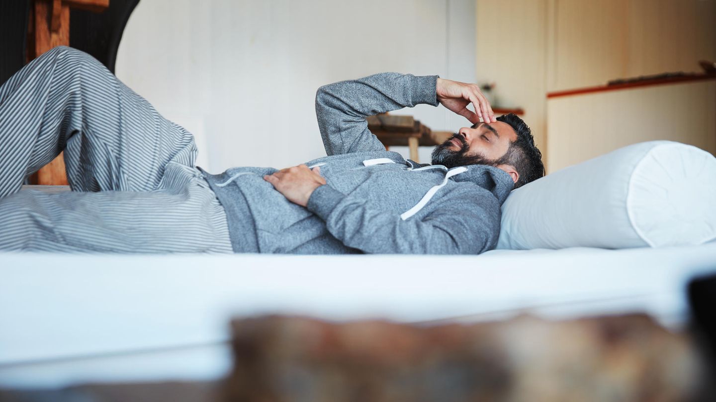 Mann liegt krank im Bett