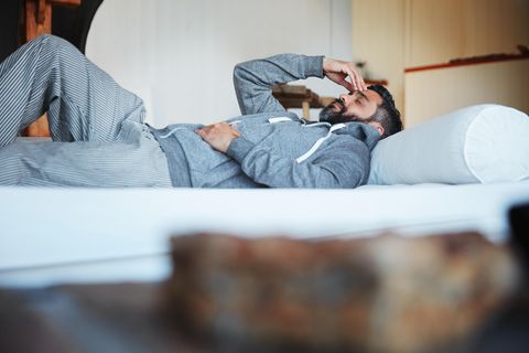 Mann liegt krank im Bett