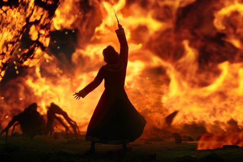 Ein Spielecharakter kämpft mit Feuer gegen Spinnen
