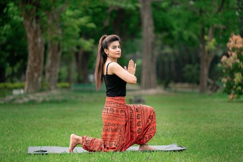 Eine Frau macht Yoga auf einer Wiese