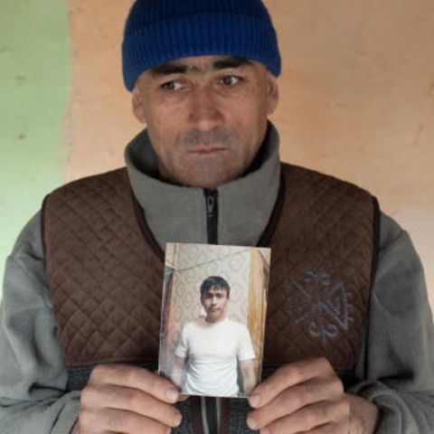 Alimbek Rakhimov hält das Foto seines verstorbenen jüngeren Bruders in die Kamera