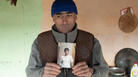 Alimbek Rakhimov hält das Foto seines verstorbenen jüngeren Bruders in die Kamera
