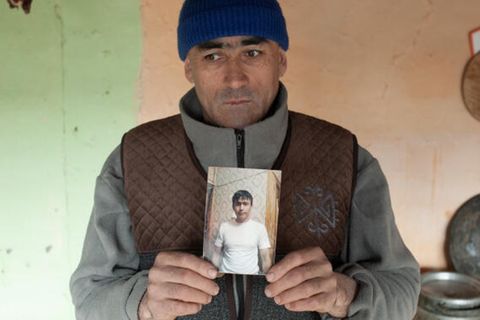 Alimbek Rakhimov hält das Foto seines verstorbenen jüngeren Bruders in die Kamera