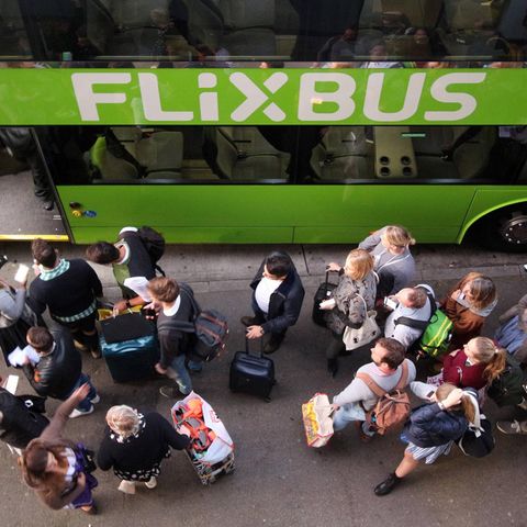 Wartende Passagiere stehen vor einem Flixbus