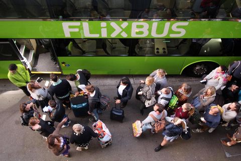 Wartende Passagiere stehen vor einem Flixbus