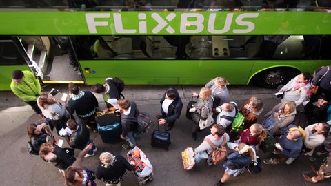 Wartende Passagiere stehen vor einem Flixbus