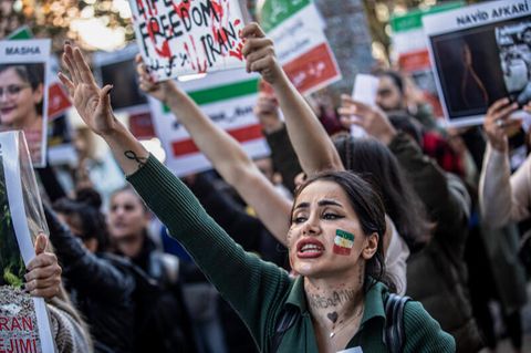 Eine Demonstrantin mit iranischer Flagge auf der Wange nimmt in der Türkei an einer Demonstration gegen das Regime im Iran teil