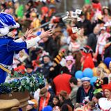 Ein Karnevalist wirft Süßigkeiten ins Publikum