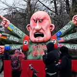 Ein Mann fotografiert einen Karnevalswagen mit Russlands Präsident Wladimir Putin als Motiv