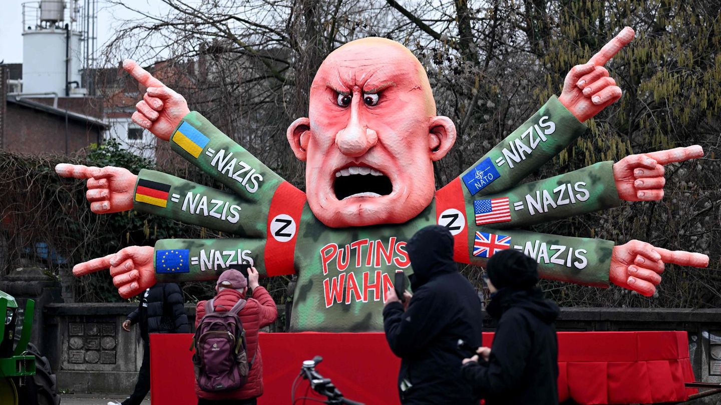 Ein Mann fotografiert einen Karnevalswagen mit Russlands Präsident Wladimir Putin als Motiv