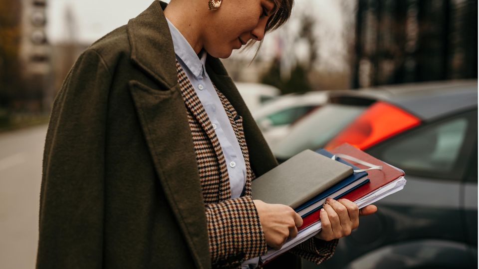 Eine Frau im Look des Dark Academia Style hält Bücher in der Hand.
