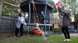 Sharon mit ihrer Partnerin und den drei Kindern beim Spielen im Garten