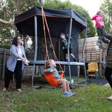 Sharon mit ihrer Partnerin und den drei Kindern beim Spielen im Garten