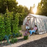 Eva Pavlič Seifert mit Mann und Kind in ihrem Garten vor einem Gewächshaus