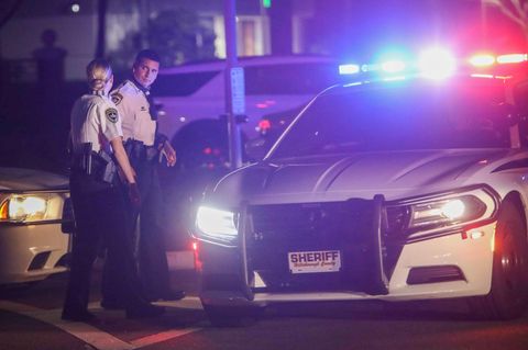 Polizisten stehen in Florida neben einem Polizeiauto