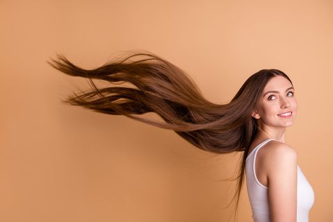 Eine Frau mit langen Haaren, die in der Luft fliegen.