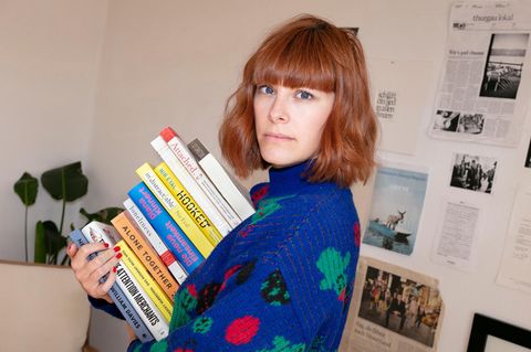 Anna Miller ist Autorin und Expertin für digitale Achtsamkeit. Hier hält sie einen Stapel Bücher in der Hand.