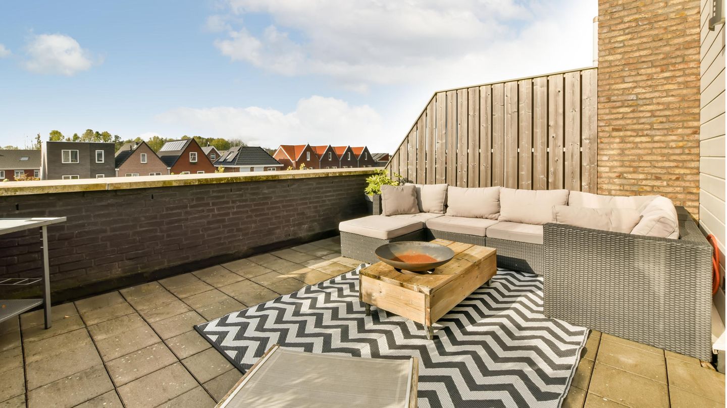 Balkonteppich: Teppich mit geometrischem Motiv liegt auf einer wohnlich eingerichteten Terrasse